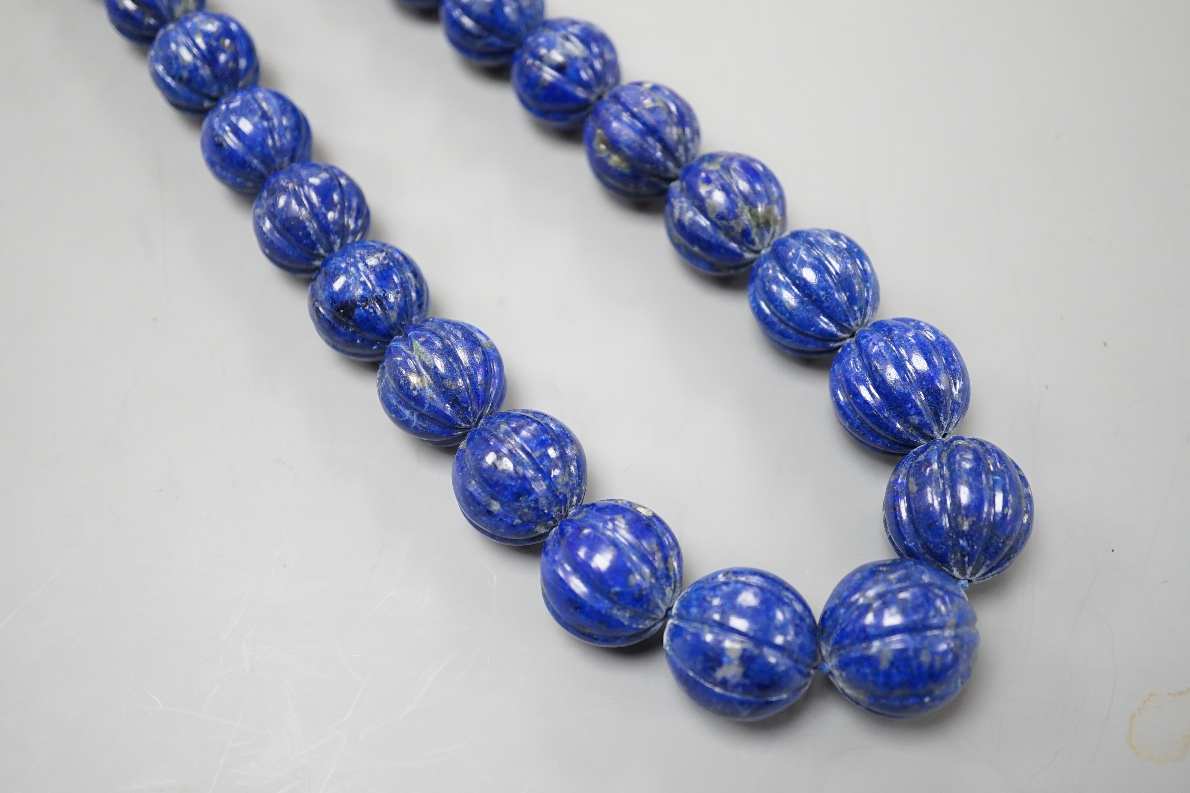 A single strand graduated fluted lapis lazuli bead necklace, 44cm